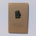 Brown card with a camera charm and text on a white background