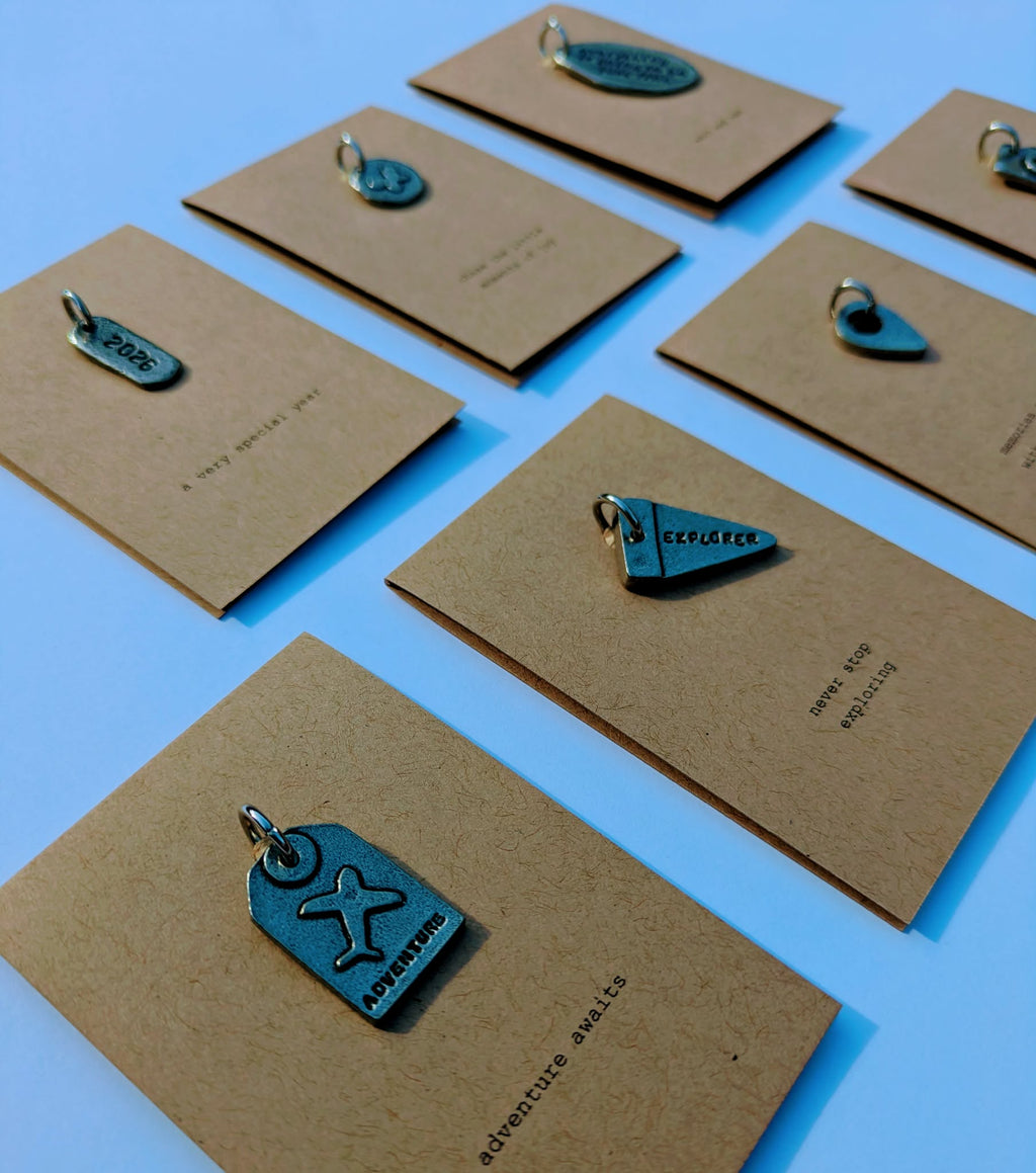 Brown cards with metal charms on a white background
