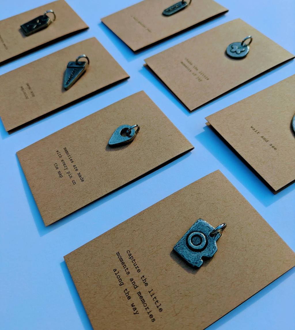 Brown cards with metal charms on a white background