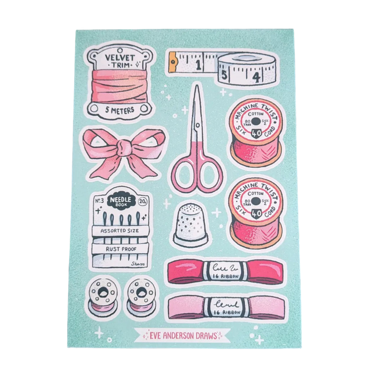 A sheet of sewing-themed stickers on a light blue background, featuring illustrations of pink thread spools, scissors, a tape measure, ribbon, pins, and sewing notions, placed on a dark wood surface.