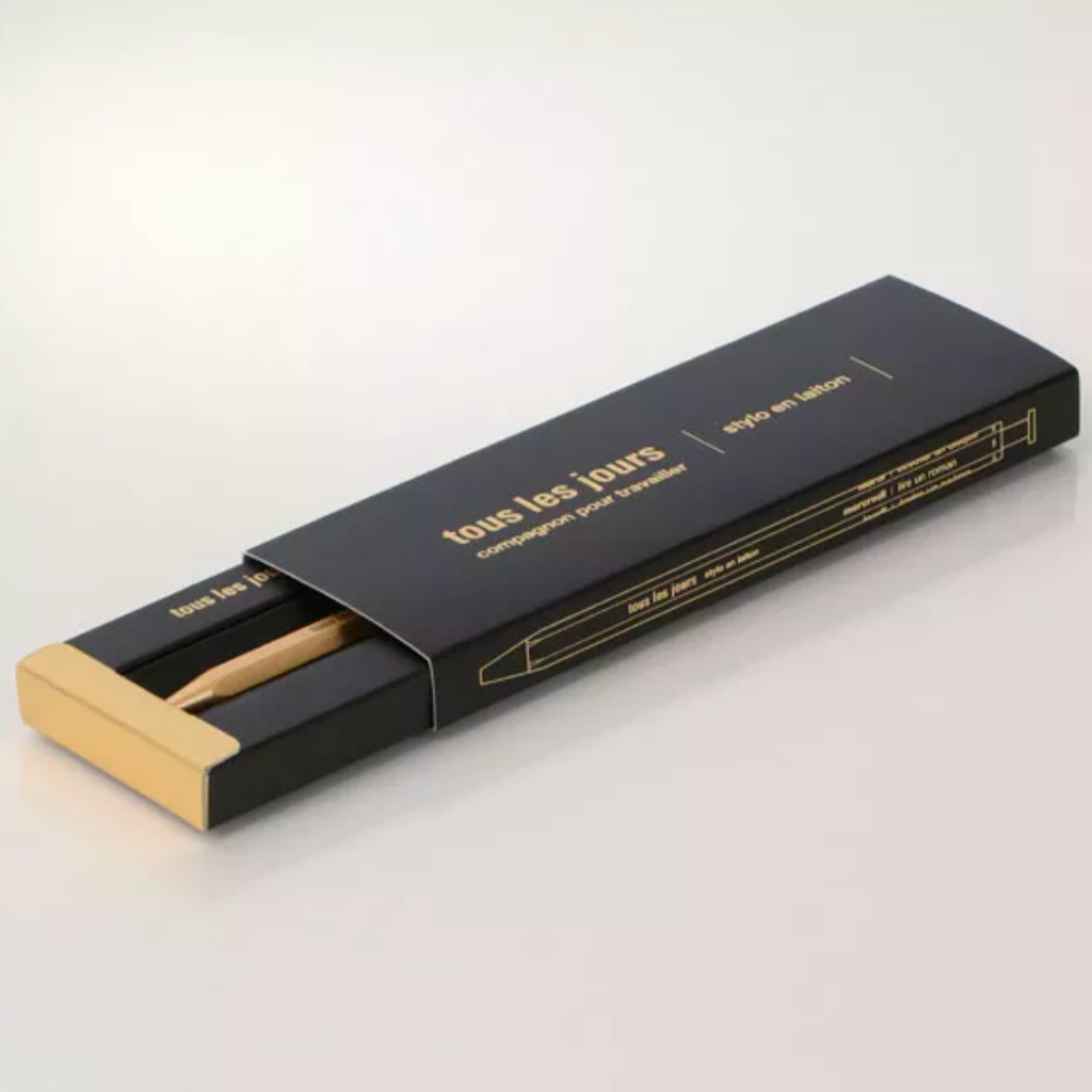 Black and gold pen packaging of 'tous les jours' on a white background