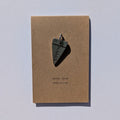 Journal metal charm on a brown card with 'never stop exploring' text on a white background