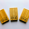 Three wooden stamps with black text and illustrations on a white background