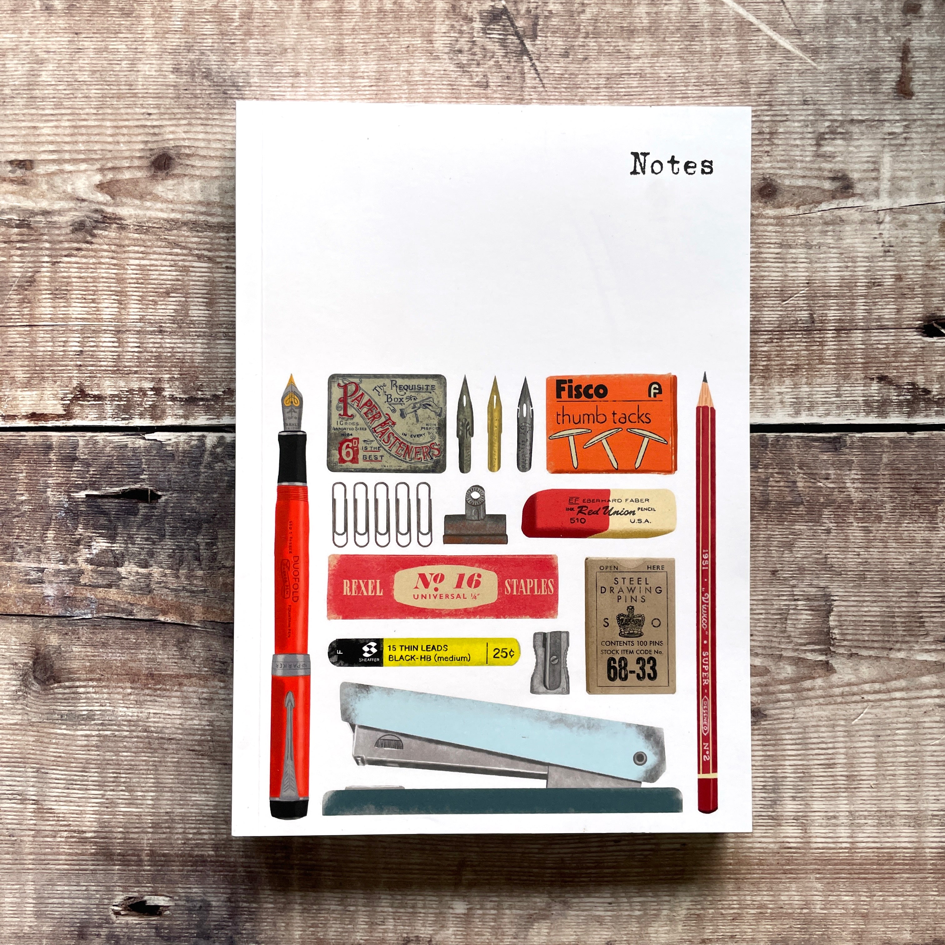 Notebook cover with stationery items on a wooden surface