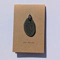 Metal charm with everything is going to be just fine printed on a brown card with text on a light gray background