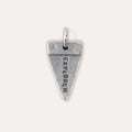 A silver triangular pendant charm engraved with the word 'EXPLORER' vertically, shown on a light beige background.
