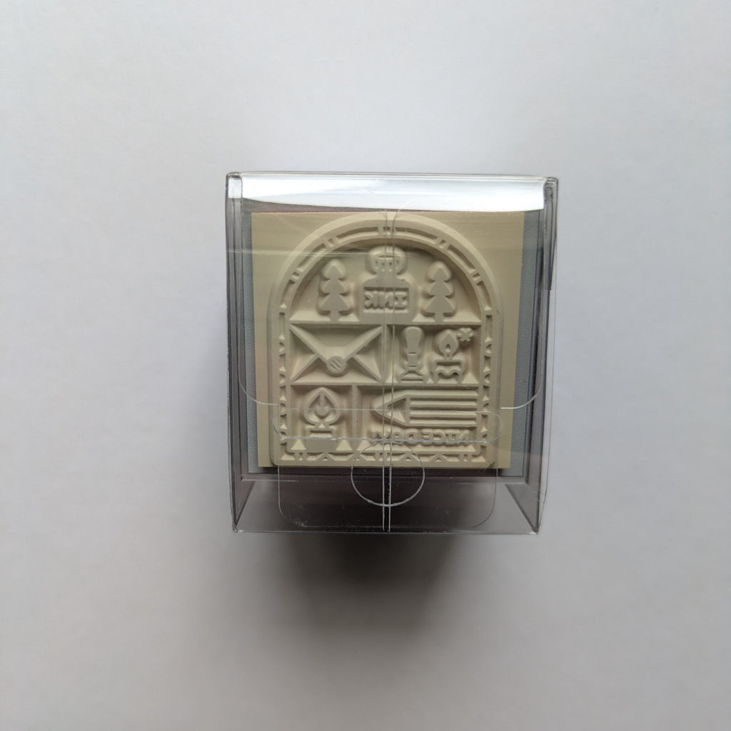 Decorative rubber stamp in a clear holder on a light gray background