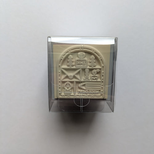 Decorative rubber stamp in a clear holder on a light gray background