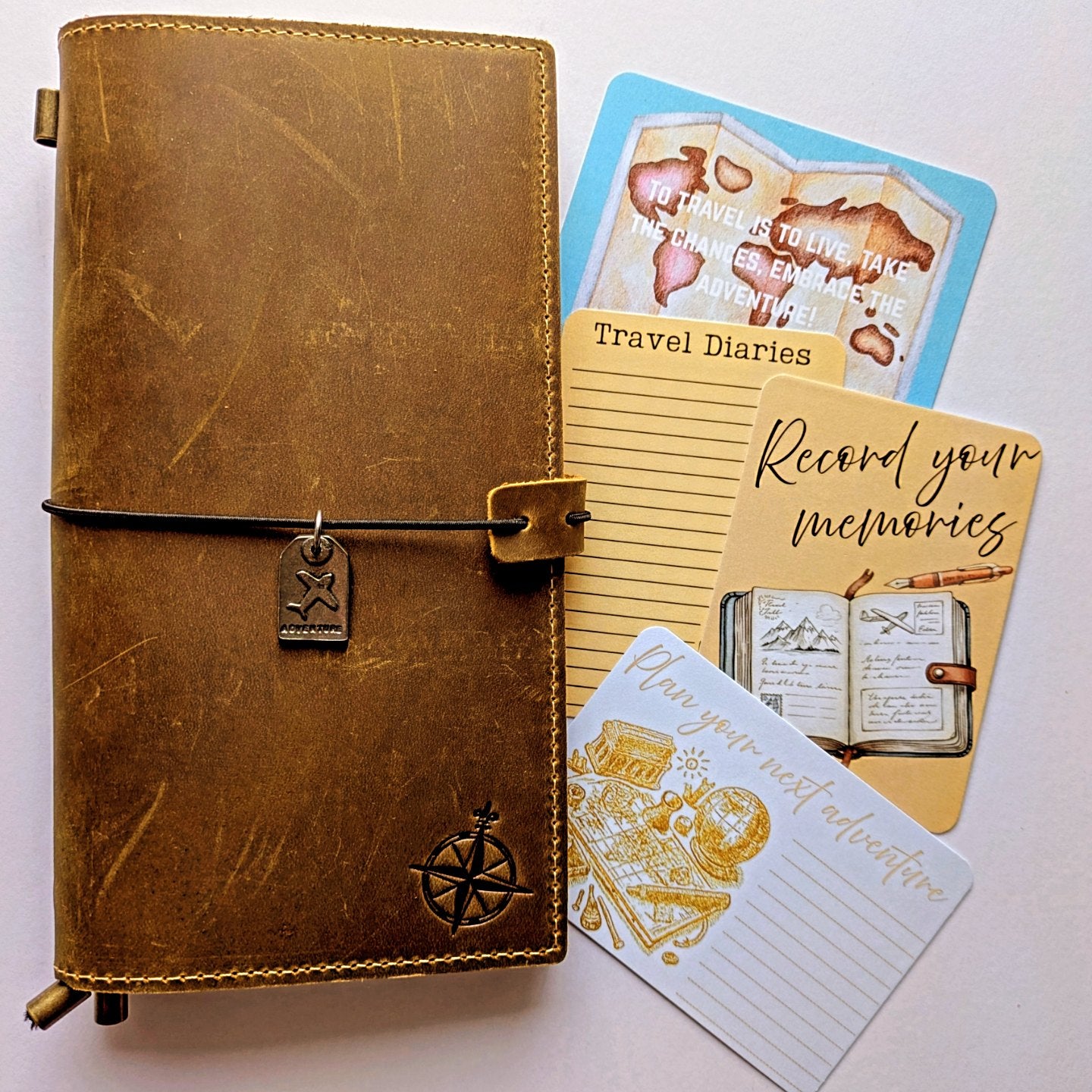 Brown leather travel diary with cards on a white background