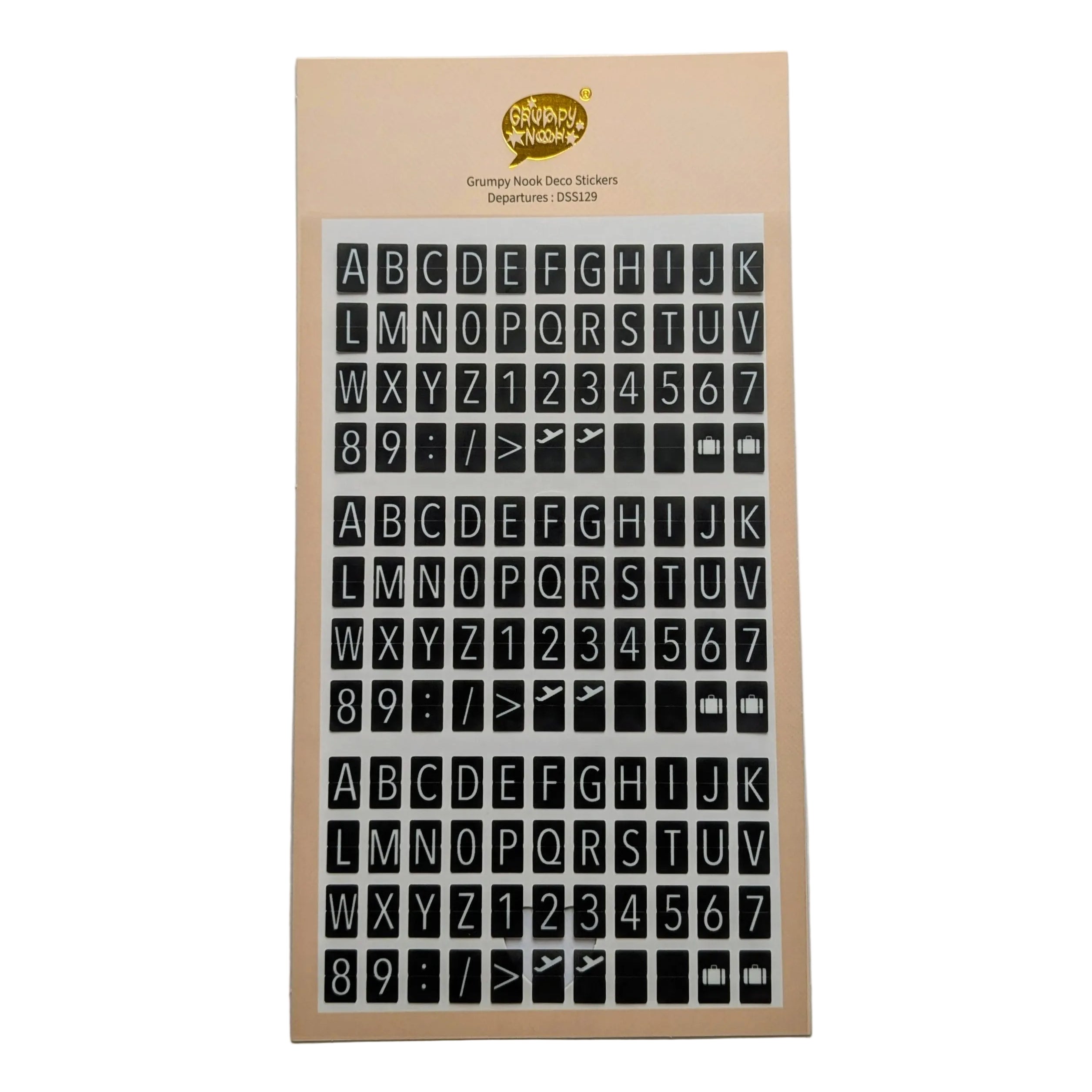 A sheet of alphabet and number stickers on a beige backing card, photographed against a plain light gray background. In the style of travel departures boards 