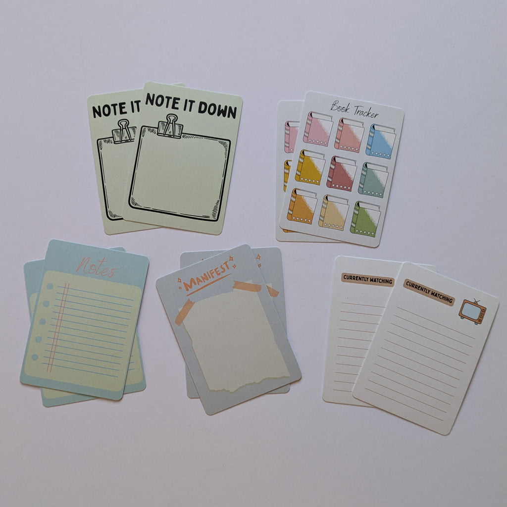 Set of small stationery items including postcards and note cards on a white surface