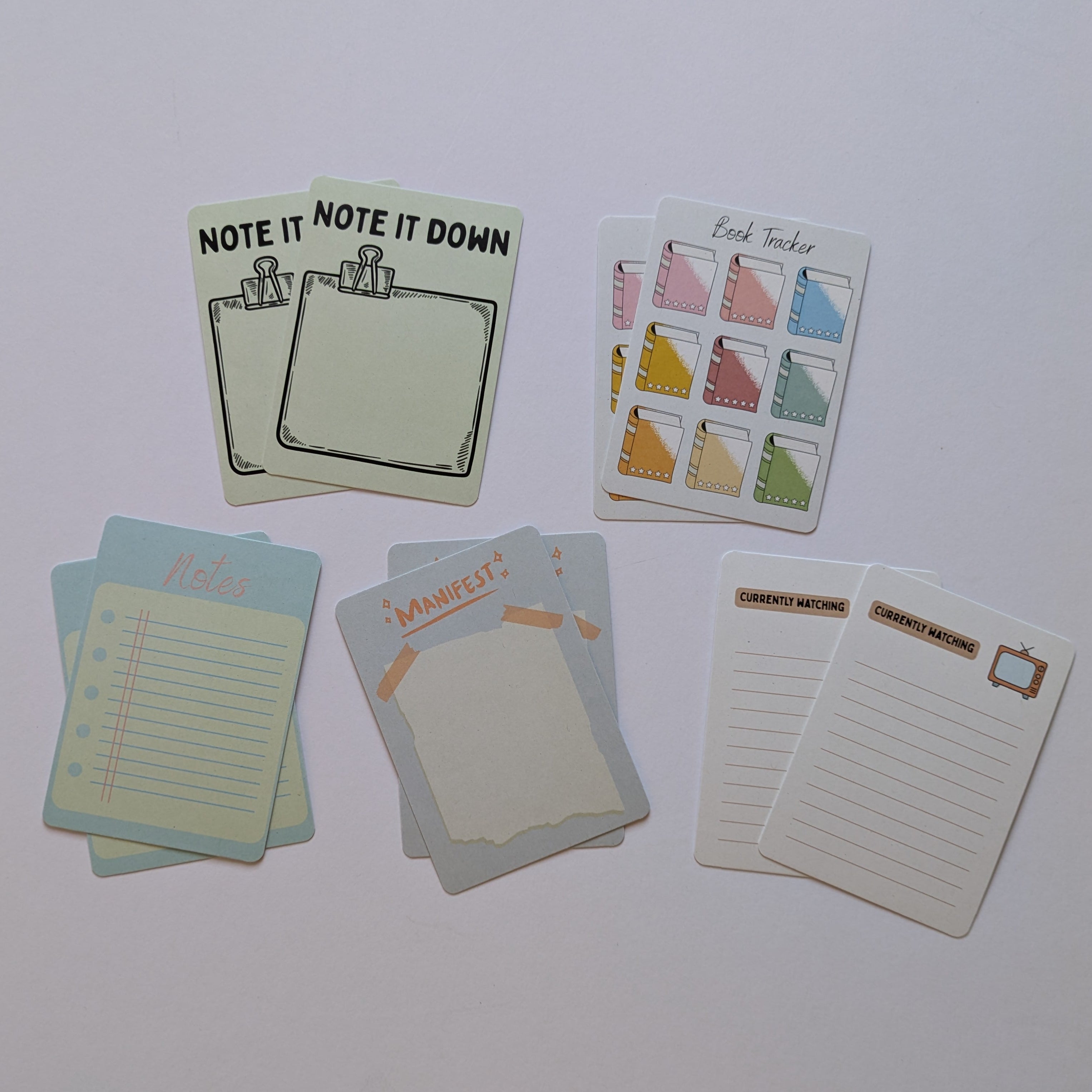 Set of small stationery items including postcards and note cards on a white surface