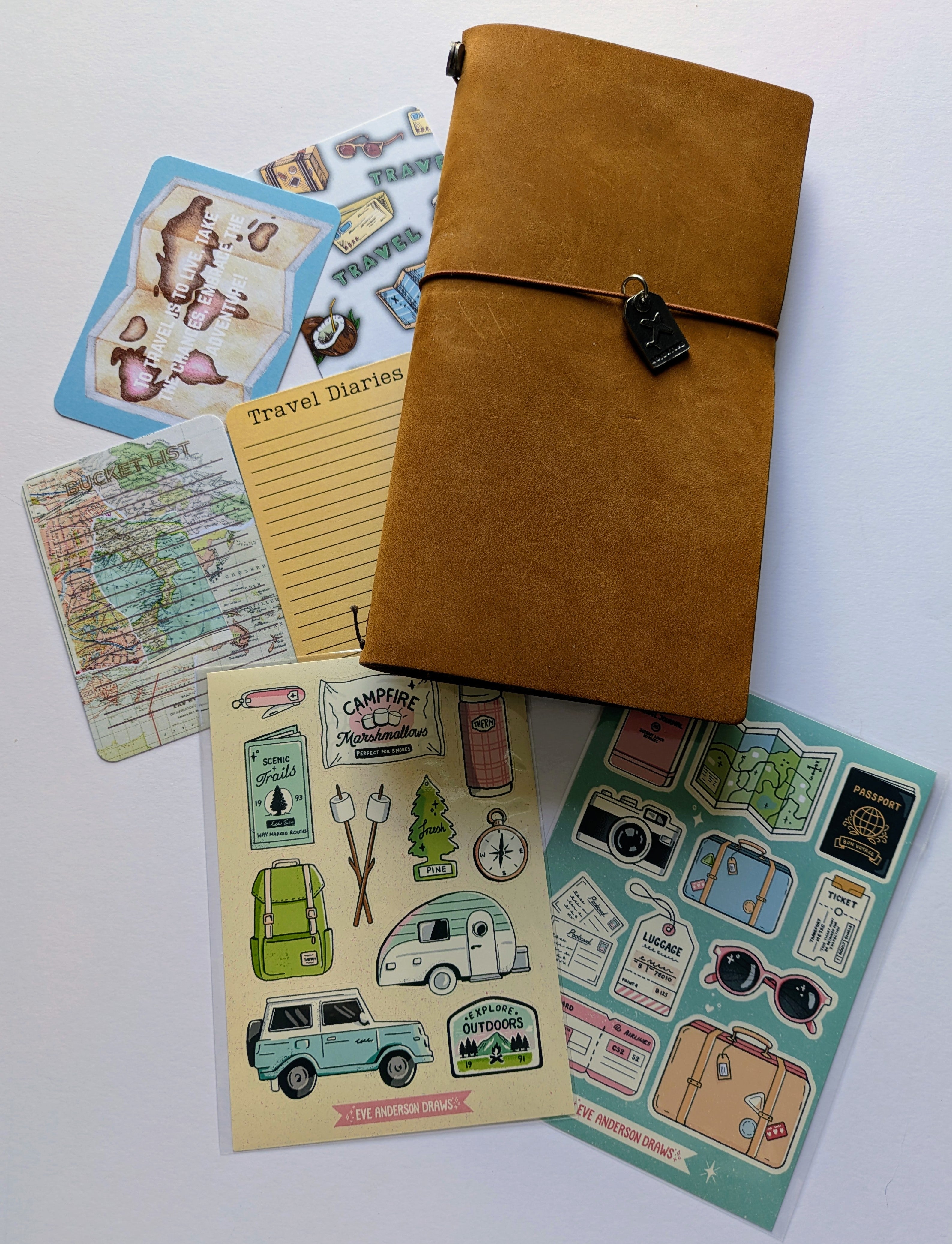 Brown leather travel journal with stickers and paper sheets on a white background
