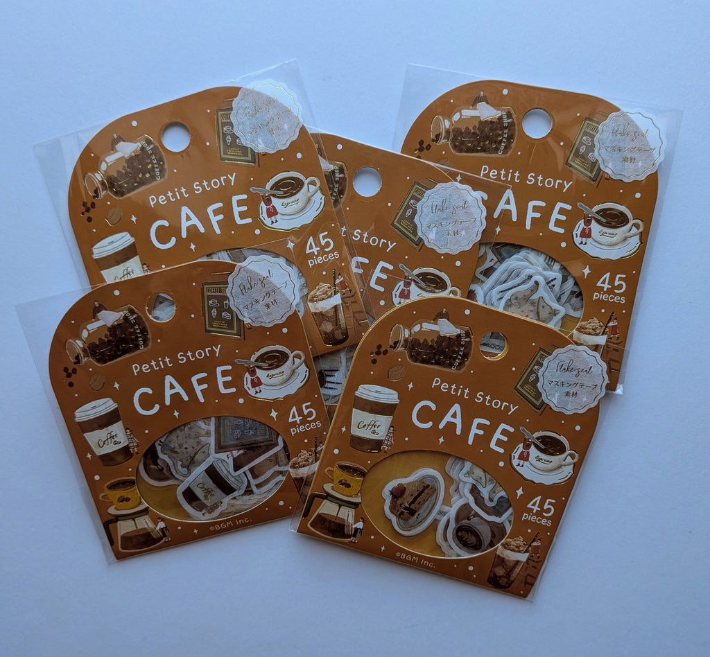 Four small retail packages of decorative stickers arranged on a light blue background. Each package is brown with coffee-themed illustrations and the text 'Petit Story CAFE' and '45 pieces'.