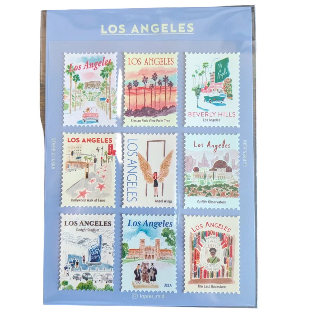 A sheet of nine Los Angeles postage stamps displayed in a clear protective sleeve, placed on a dark wooden surface. The sheet is labeled 'LOS ANGELES' at the top and features various colorful illustrated stamps representing different neighborhoods and landmarks.