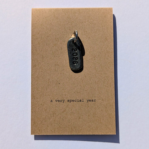 Keychain with '2026' on a card reading 'a very special year' on a light white background
