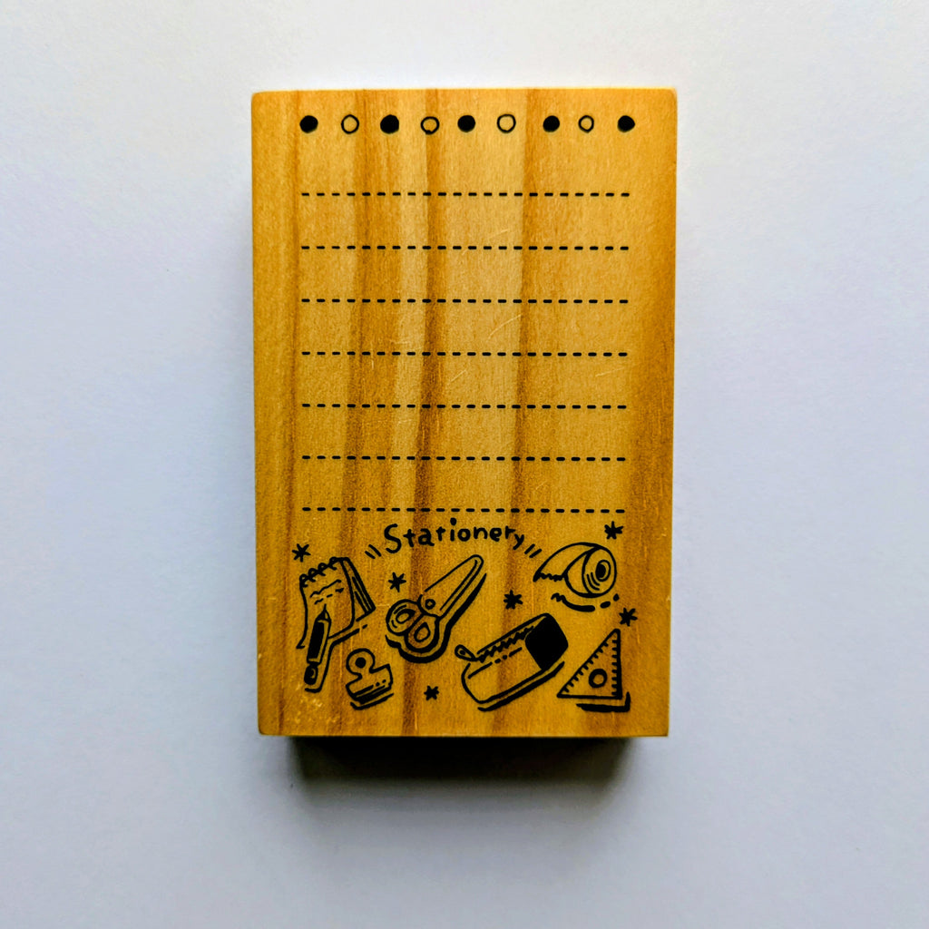 Wooden stamp with stationery illustrations on a white background