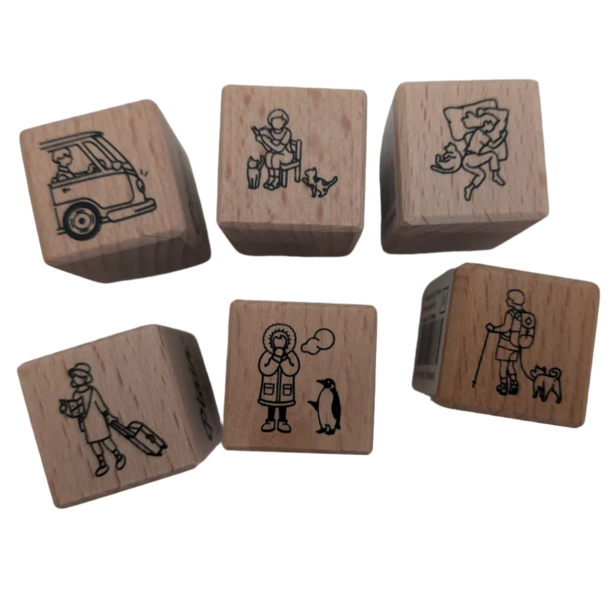 Six wooden stamp blocks with black printed illustrations of characters, and objects, arranged on a plain light background.